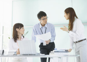 オフィスで打ち合わせをする3人のスタッフ